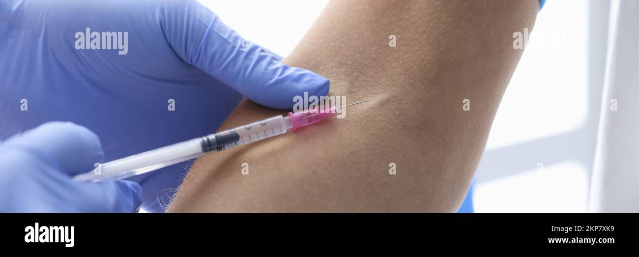Nurse injects medication in womans vein with needle, blood test in hospital Stock Photo