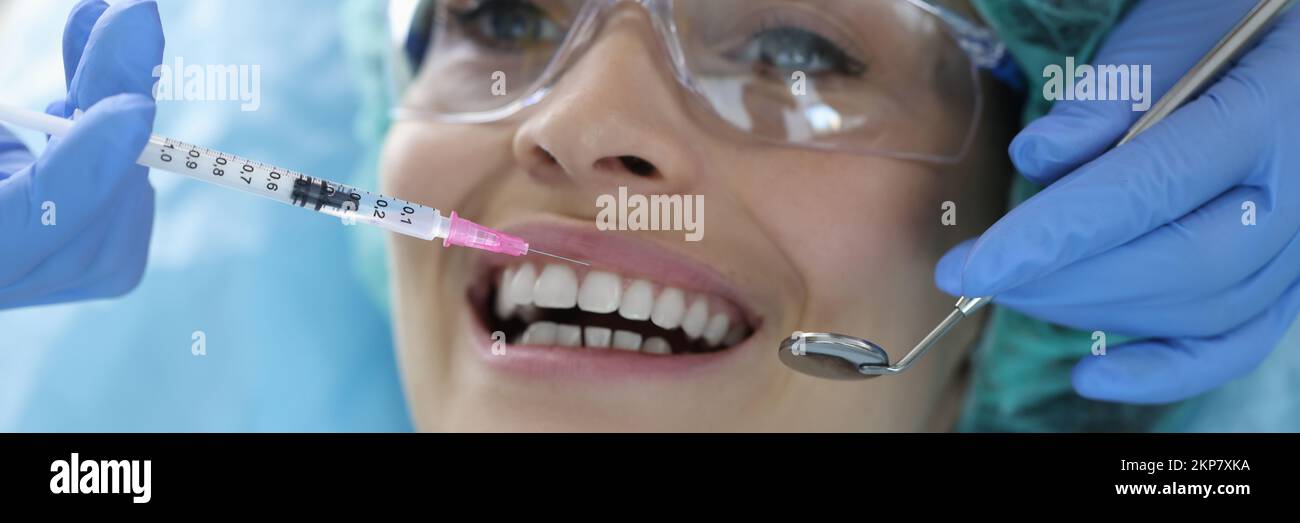 Female client on appointment in stomatology cabinet, syringe with painkiller liquid Stock Photo