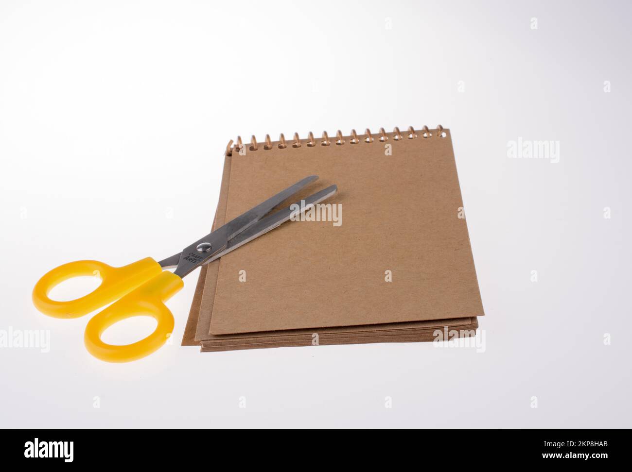 Spiral notebook and scissors on a white background Stock Photo