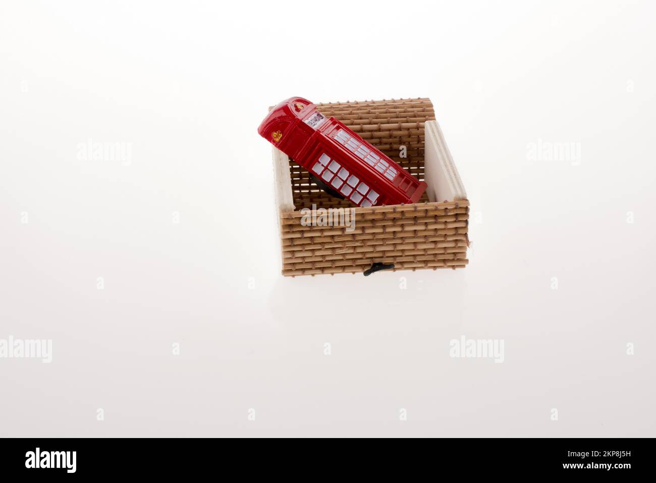 Isolated telephone booth in a straw box on white background Stock Photo