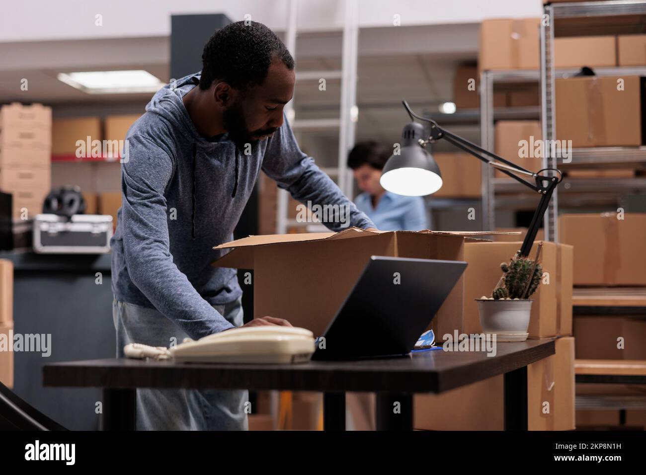 Worker putting client order in cardboard box wrapping with bubble wrap ...