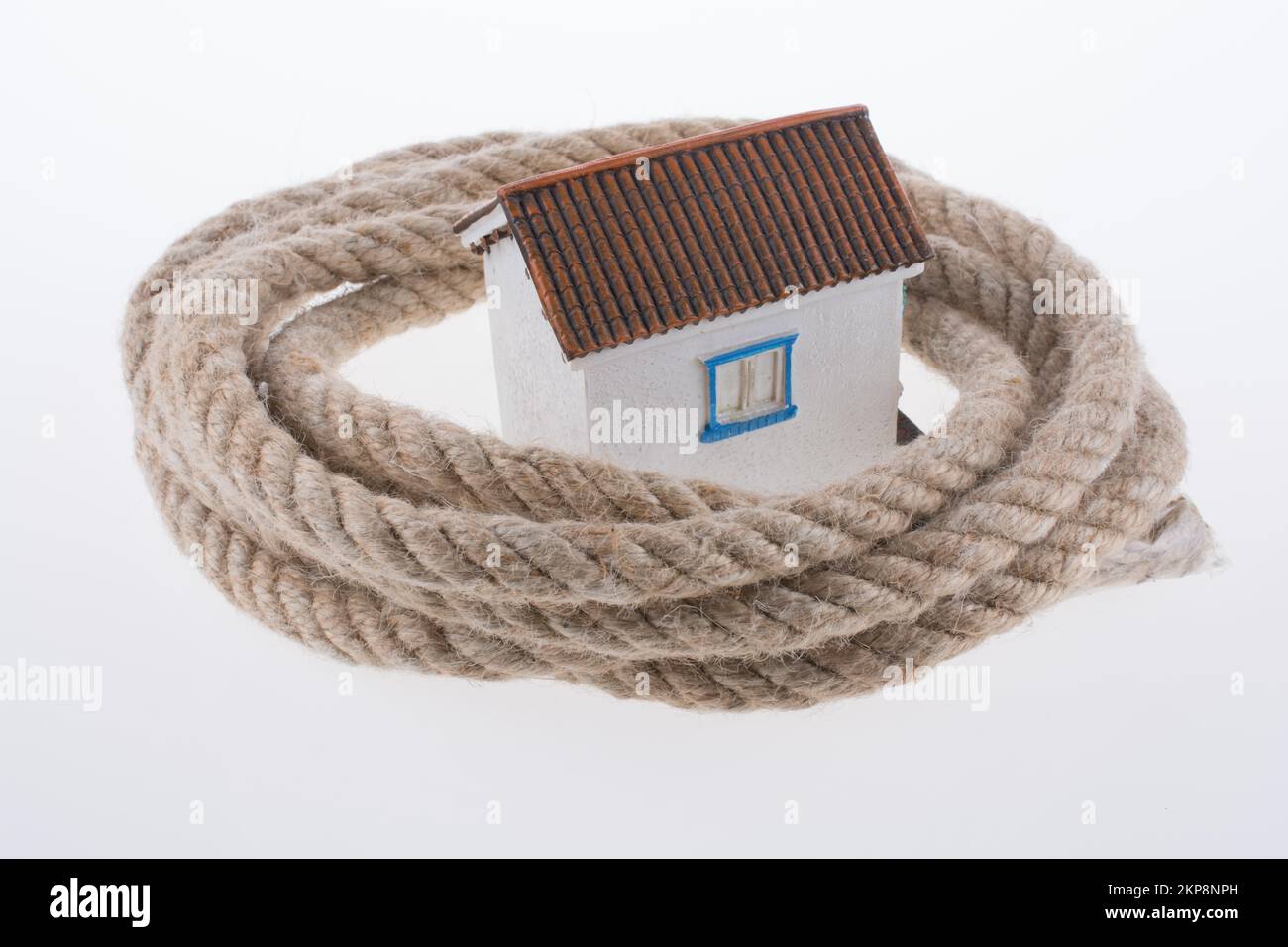 House surrounded by rope on a white background Stock Photo