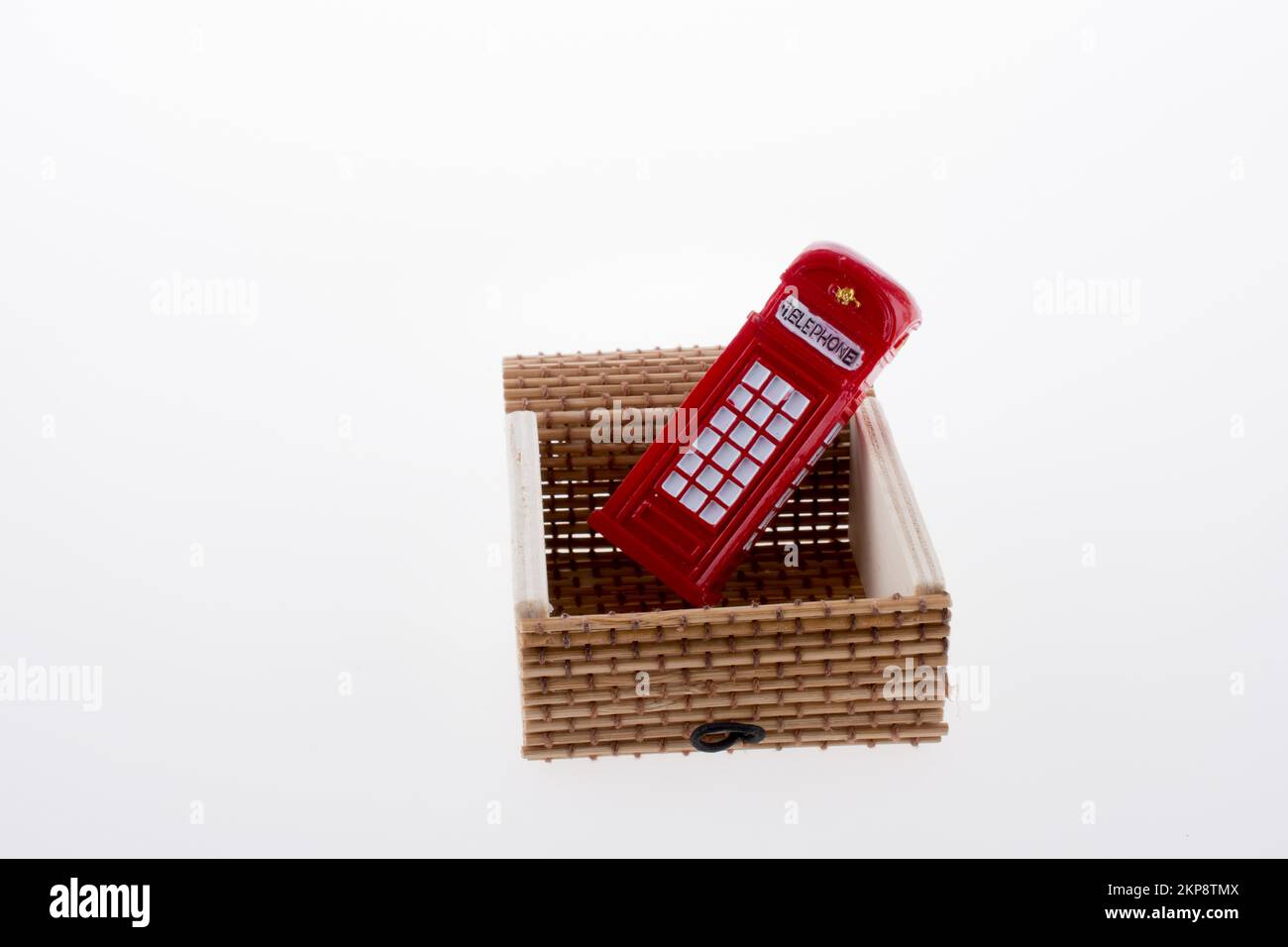 Isolated telephone booth in a straw box on white background Stock Photo