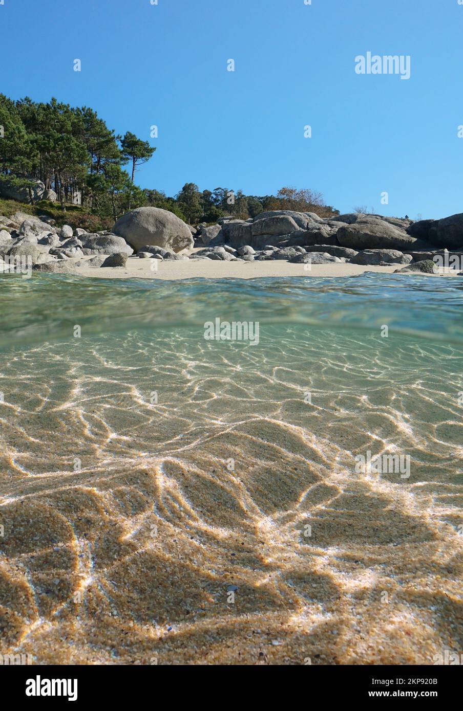 Beach with rocks and sand underwater, sea shore over and under water surface, split level view, Atlantic ocean, Spain, Galicia, Rias Baixas Stock Photo