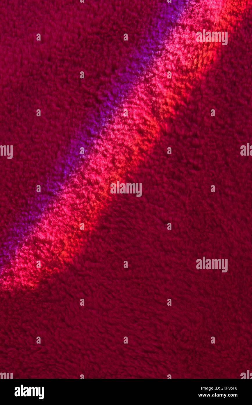 Bright ray of light fallen on wine red carpet close view Stock Photo