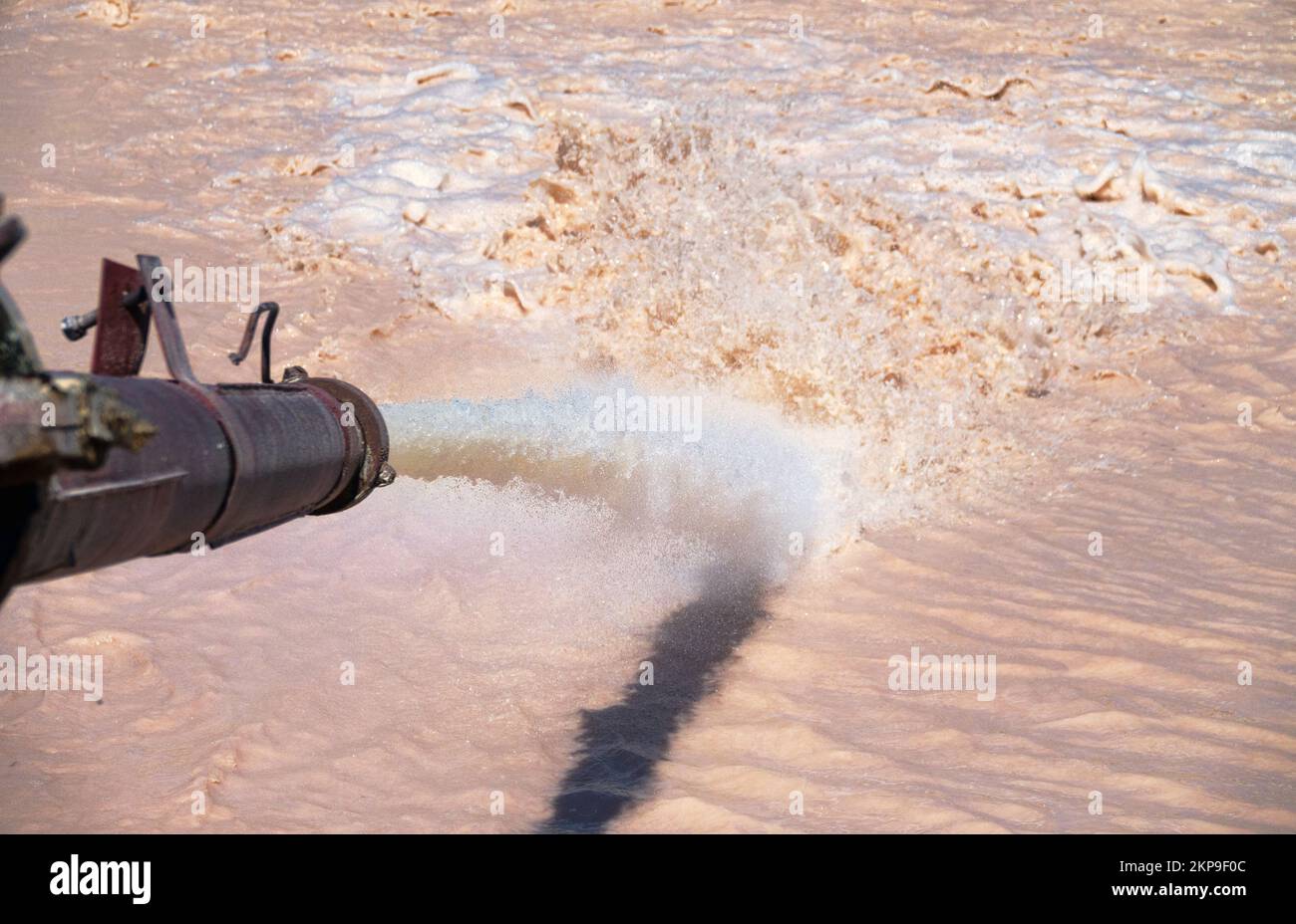 Foamy muddy water gushes out of the pipe under high pressure. Discharge