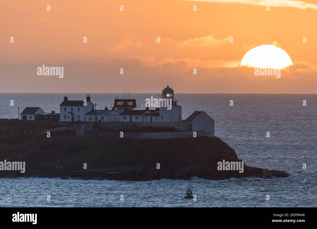 Roches Point, Cork, Ireland. 28th November, 2022. The Sun rising behind clouds at the Roches Point Lighthouse in Cork Harbour, Co. Cork, Ireland. - Credit; David Creedon / Alamy Live News Stock Photo