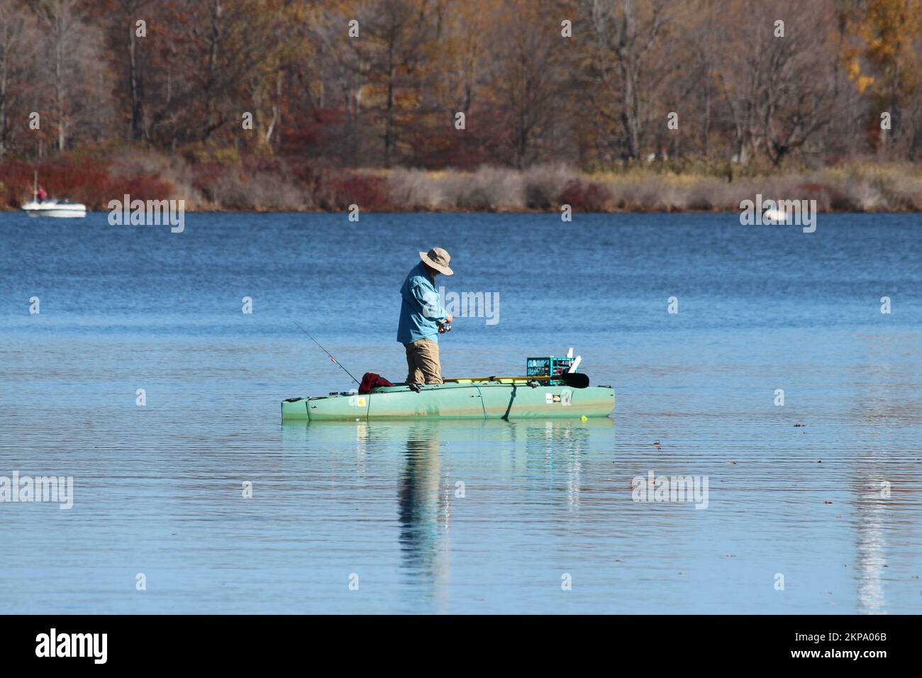 A man on a kayak fishing at Presque Isle Bay in Erie on a beautiful autumn day Stock Photo
