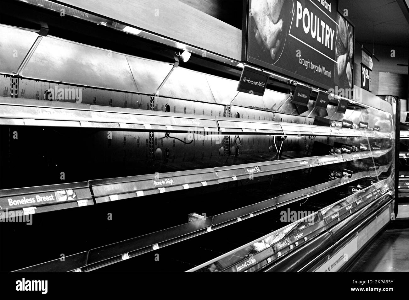 A grayscale of supermarket empty shelves - food shortage during Coronavirus Pandemic Stock Photo