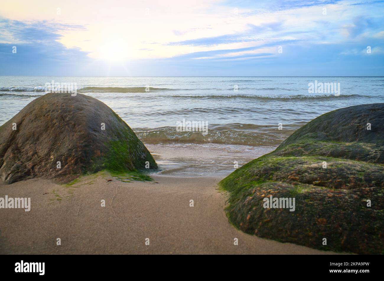 Big stone on the sandy beach in front of the sea with clouds in the sky. Denmark in Scandinavia. Landscape shot from nature in the north Stock Photo