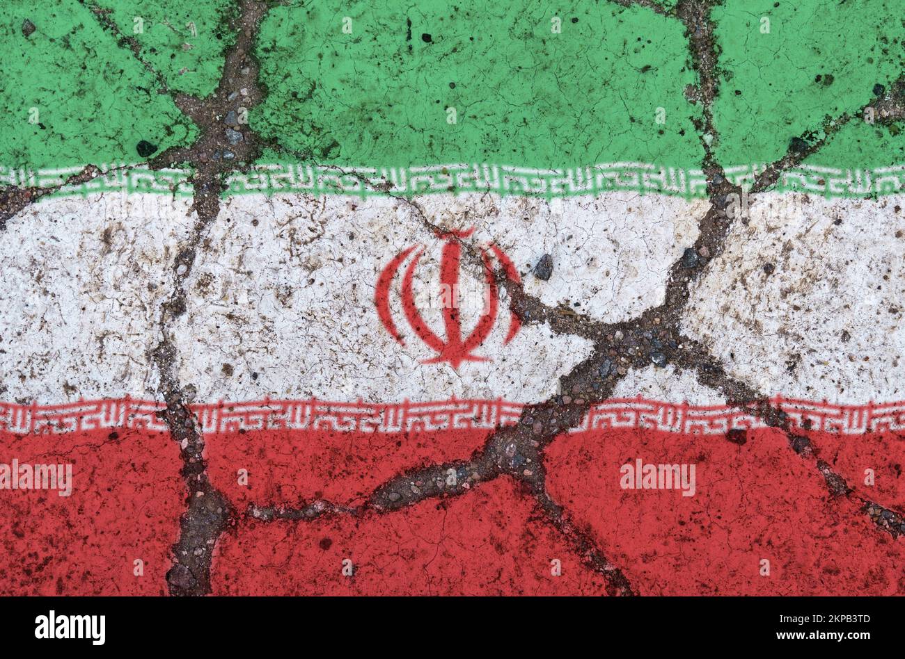 Iraqi flag on cracked asphalt. The concept of crisis, default, economic collapse, pandemic, conflict, terrorism in the country. Out of focus image Stock Photo
