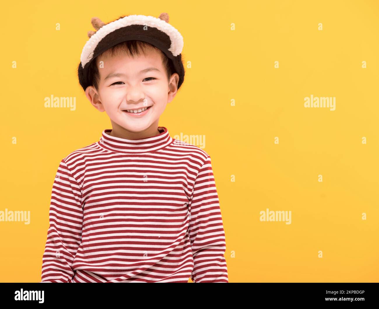 Happy kid dressed in christmas  hat and looking at camera Stock Photo