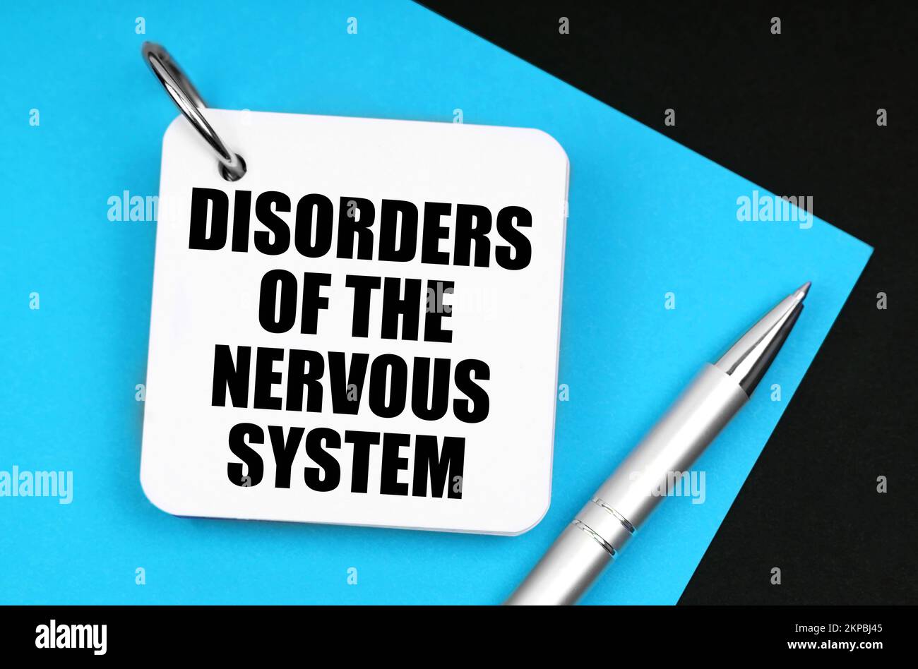 Medicine and health concept. On the black surface lies blue paper, a pen and a notebook with the inscription - disorders of the nervous system Stock Photo