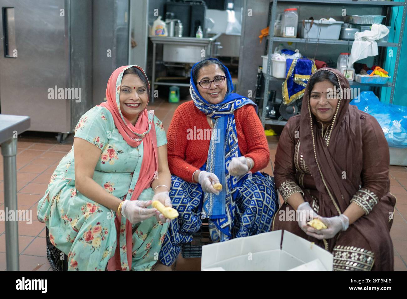 Posed portrait of 3 Sikh women who volunteer preparing food for the temple langar. In Queens, New York. Stock Photo