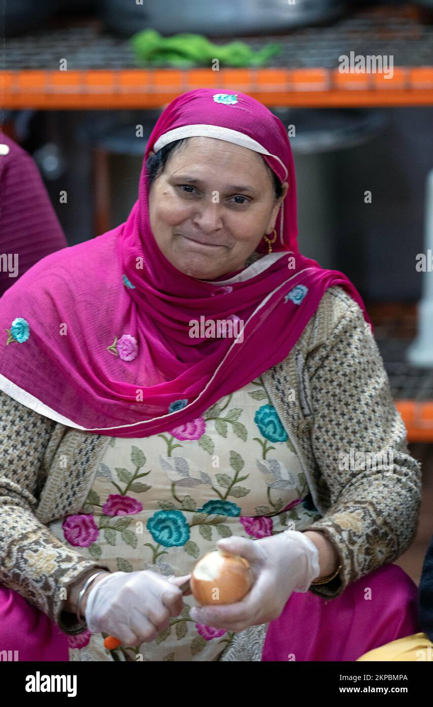 A Sikh woman volunteering in her temple's langar, a communal kitchen offering free vegetarian food to all visitors In Richmond Hill, Queens, NYC. Stock Photo