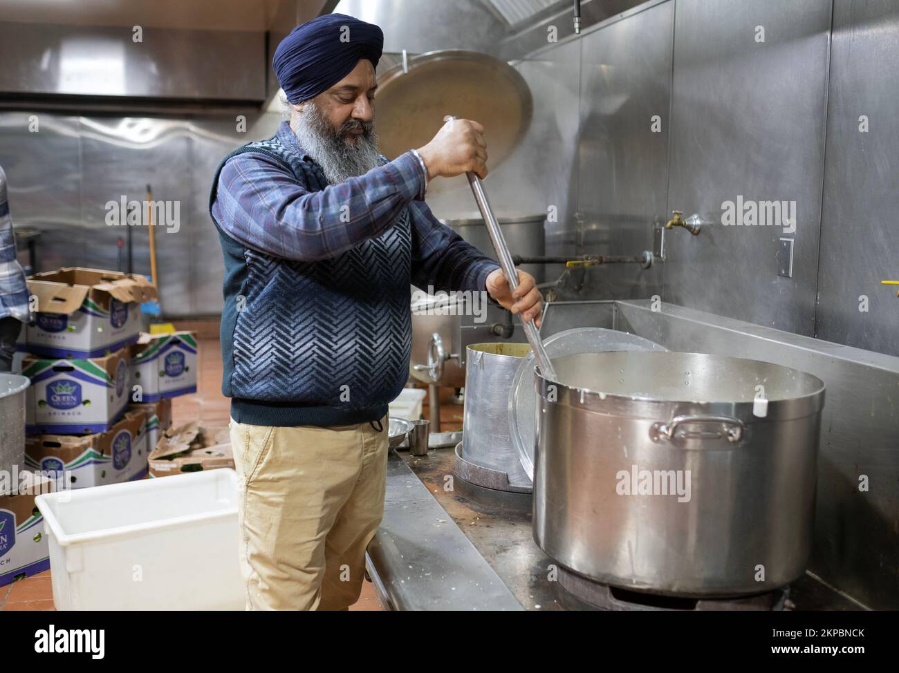 A middle aged Sikh man volunteers in A langar communal kitchen. At the Sikh Cultural Society temple in Richmond Hill, Queens, New York City. Stock Photo