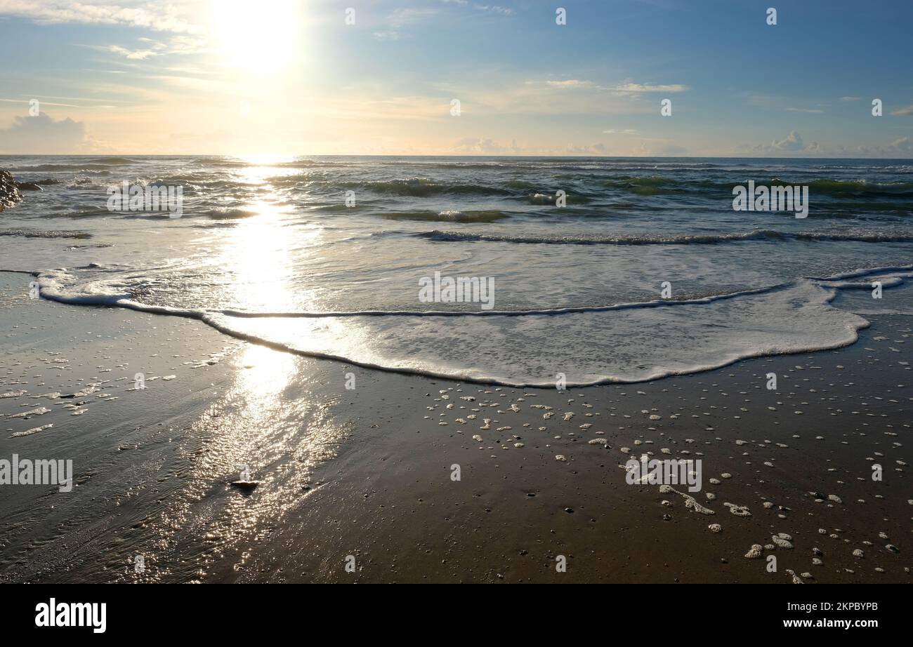 Setting sun over the ocean at Gunwalloe, Cornwall, UK - John Gollop Stock Photo
