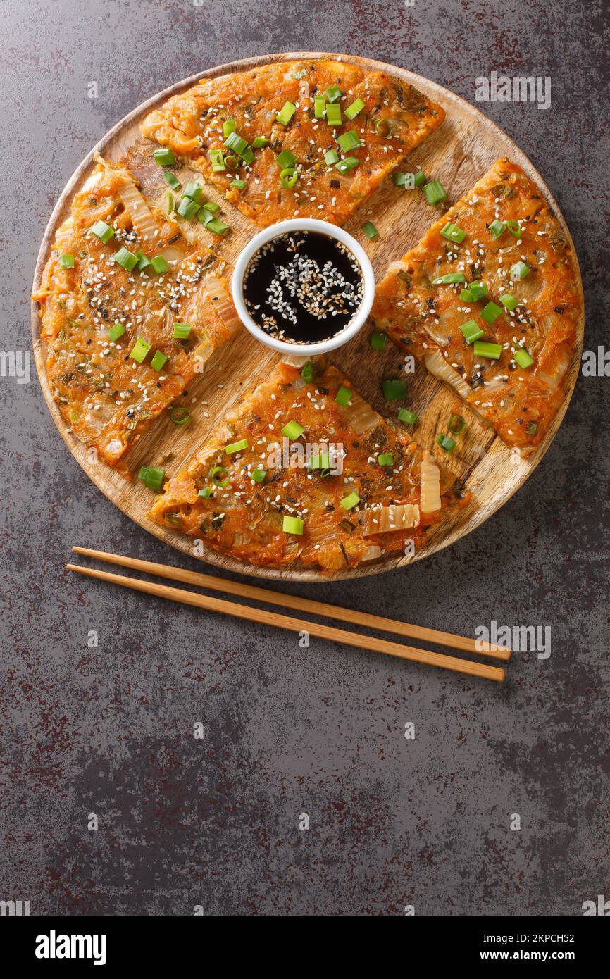 Kimchijeon South Korean pancake incorporates sliced kimchi served with a dipping sauce and sprinkled with sesame seeds and green onion closeup on the Stock Photo