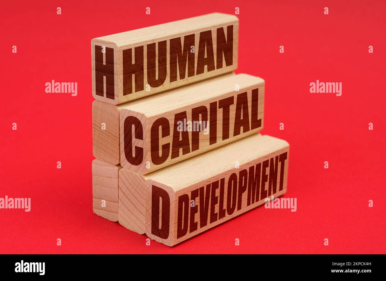 Business and economy concept. On a red background, wooden blocks with the inscription - Human Capital Development Stock Photo