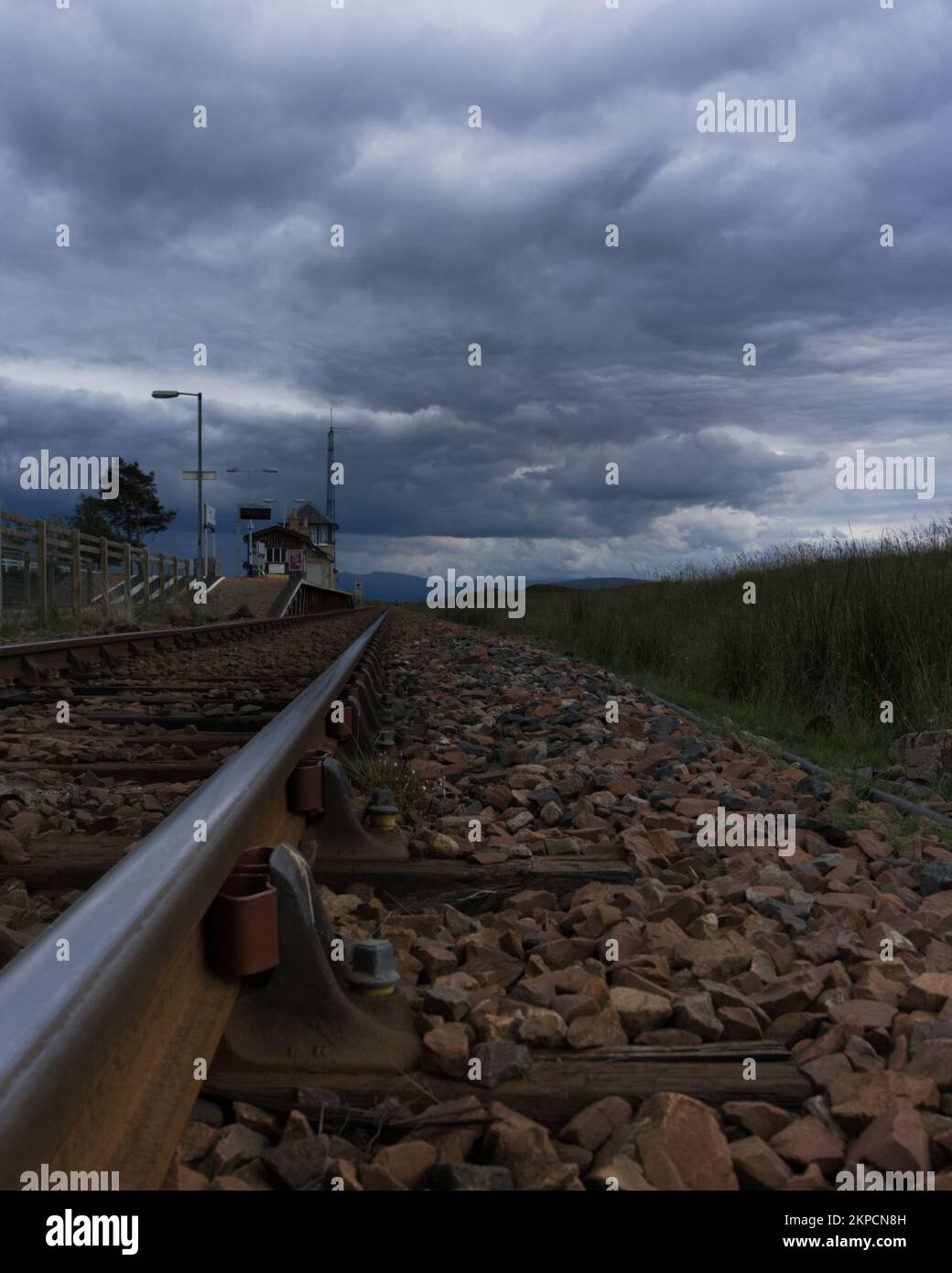 A vertical shot of an empty railroad against the cloudy sky background Stock Photo