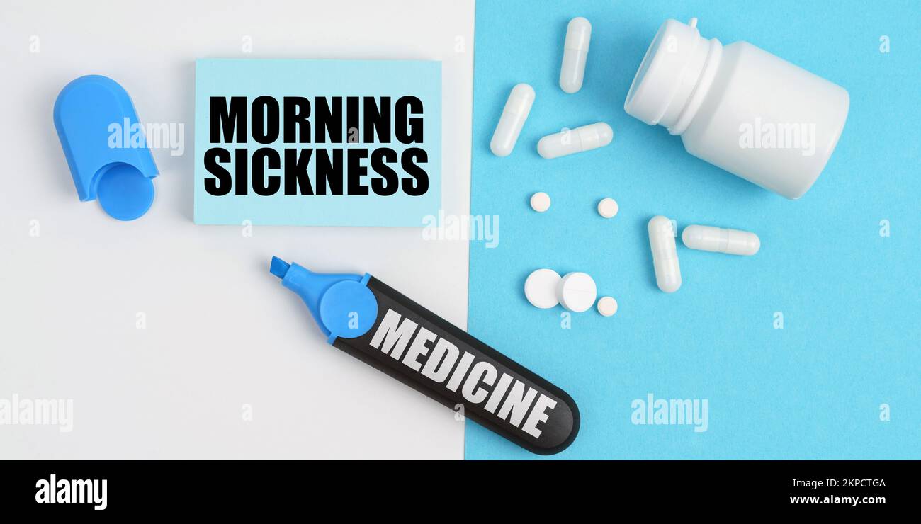 Medical concept. On the white and blue surface are pills, a marker and paper with the inscription - MORNING SICKNESS Stock Photo