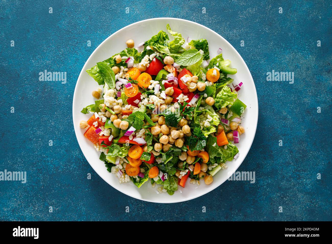 Tabbouleh salad. Tabouli salad with fresh parsley, onions, tomatoes, bulgur and chickpea. Healthy vegetarian food, diet. Top view Stock Photo