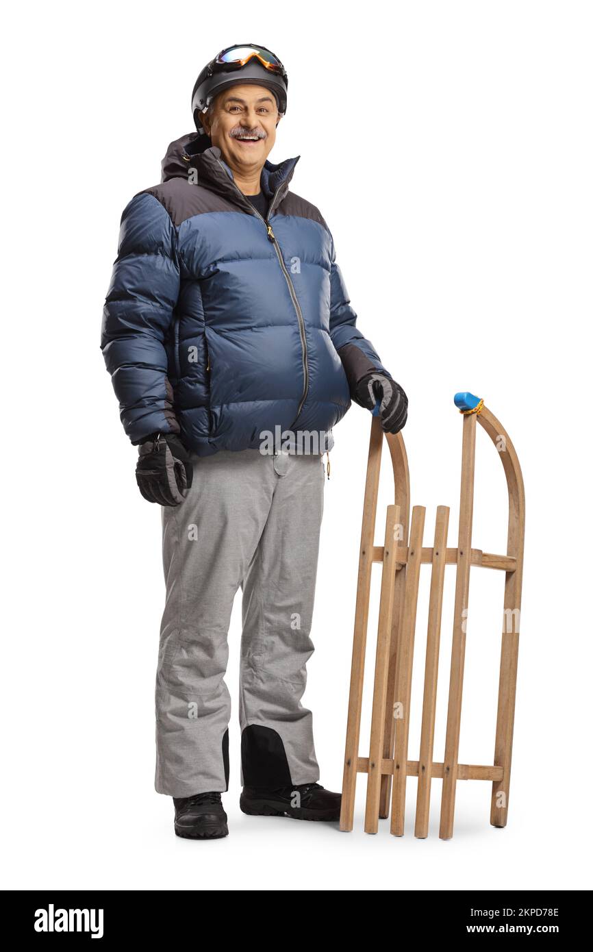 Mature man in winter clothes standing with a wooden sleigh isolated on white background Stock Photo