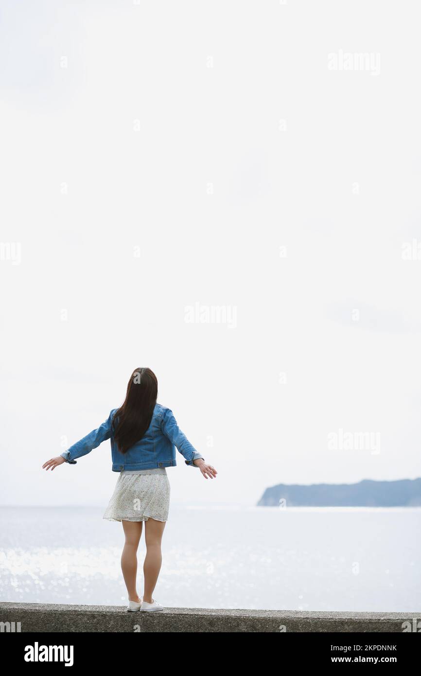 Young Japanese woman standing on the sea barrier Stock Photo - Alamy