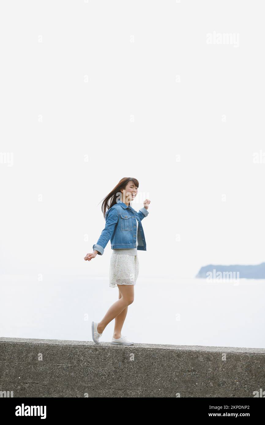 Young Japanese woman standing on the sea barrier Stock Photo - Alamy