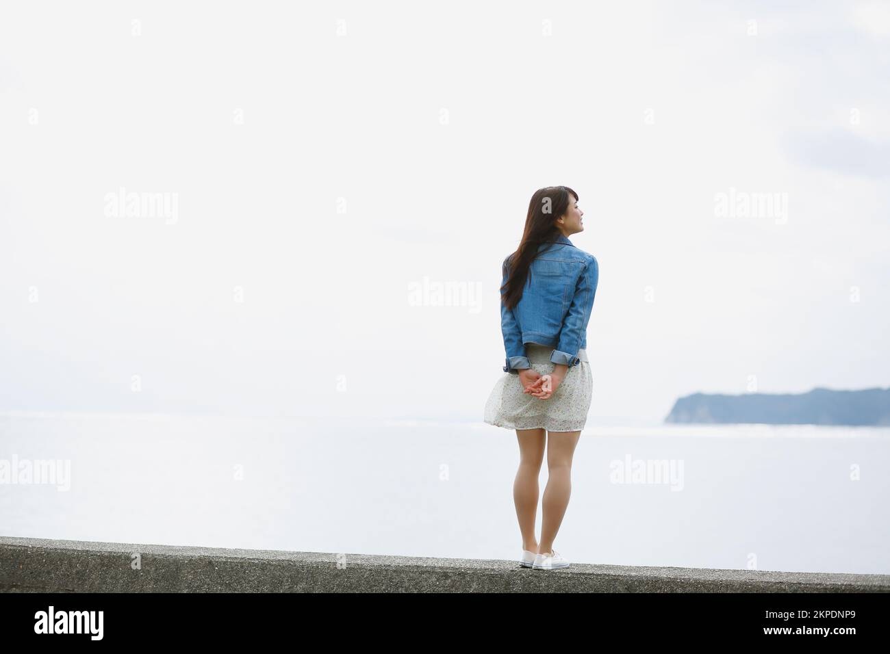Young Japanese woman standing on the sea barrier Stock Photo - Alamy