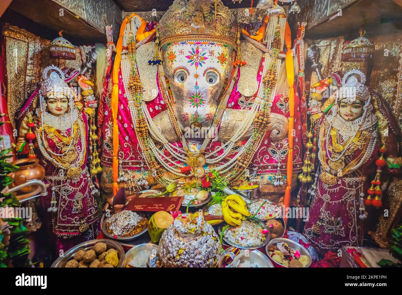 hindu god ganesha idol worshiped with flowers vertical shot from flat angle image is taken at ganesh temple ratanada jodhpur rajasthan india. Stock Photo