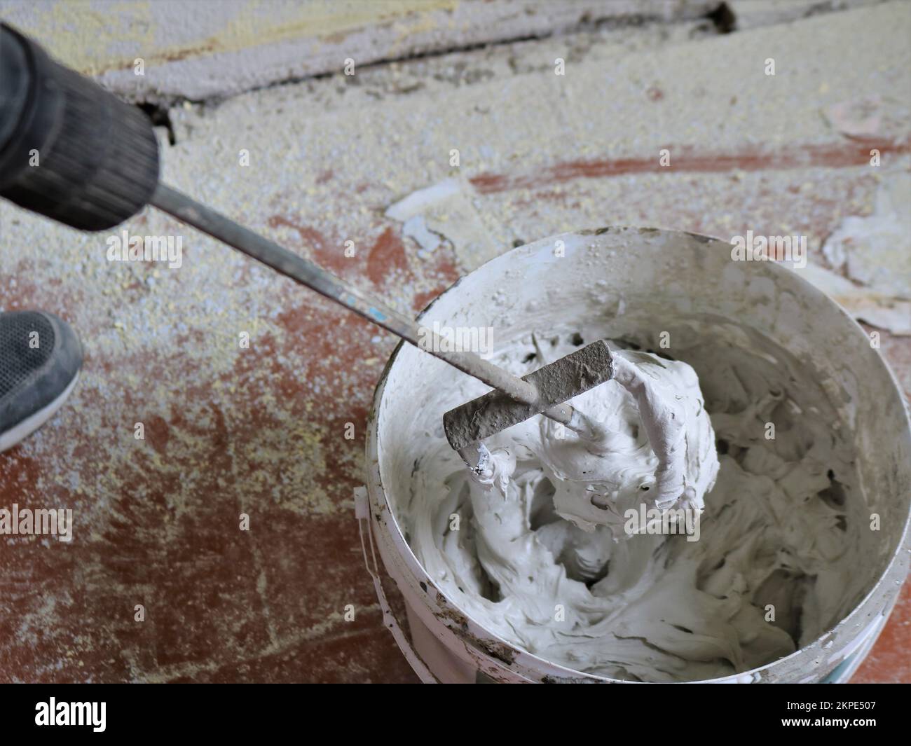 construction whisk in a thick mortar on a bucket in the process of