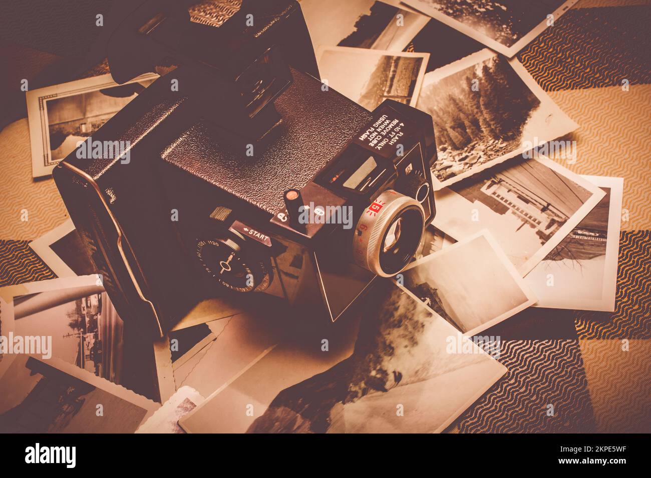 Film camera on scattered instant photos. Concepting stills Stock Photo