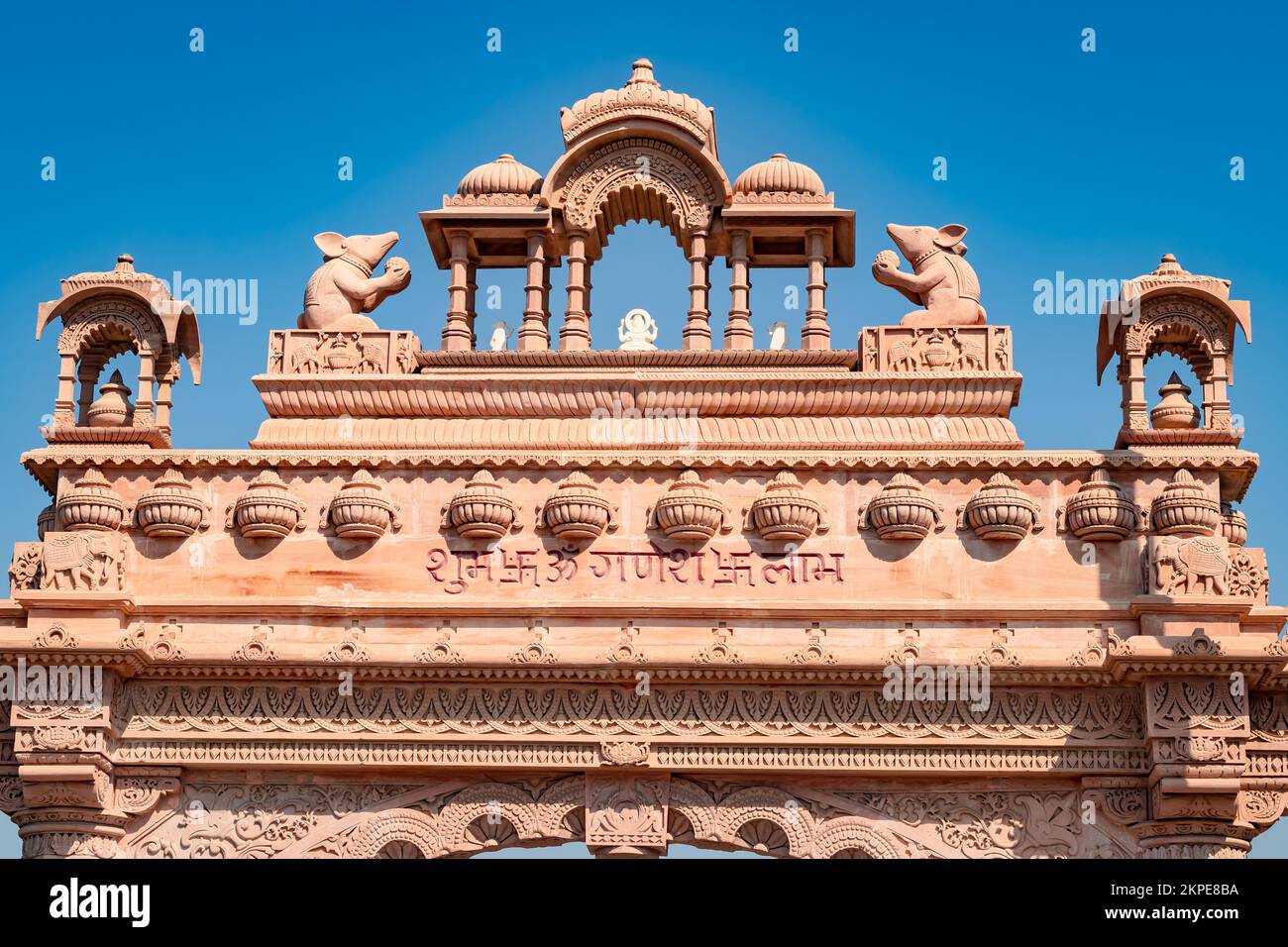 artistic temple entrance gate with bright blue sky at morning from flat angle image is taken at ratanada jodhpur rajasthan india on Nov 14 2022. Stock Photo