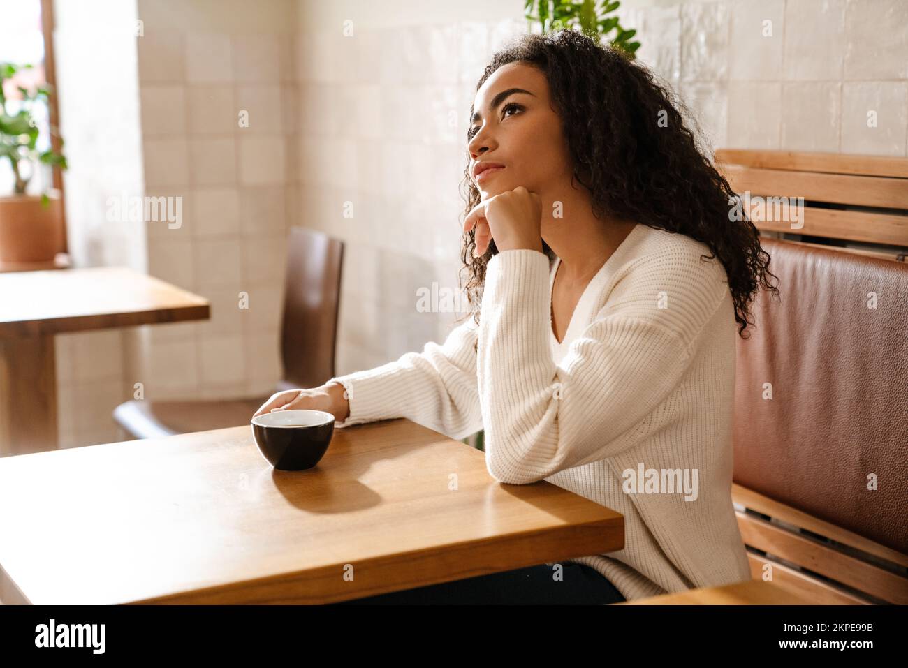 Young black woman drinking coffee while sitting in cafe indoors Stock ...