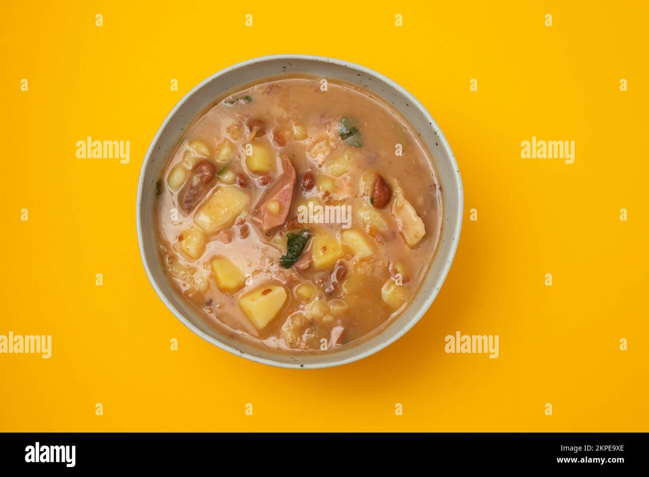 Sopa de pedra Portuguese Stone Soup with beans and sausages in the plate on yellow paper Stock ...