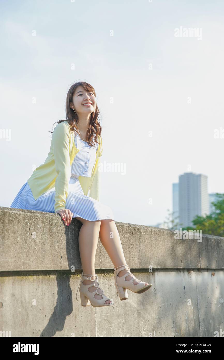 Japanese woman sitting on the sea barrier Stock Photo - Alamy