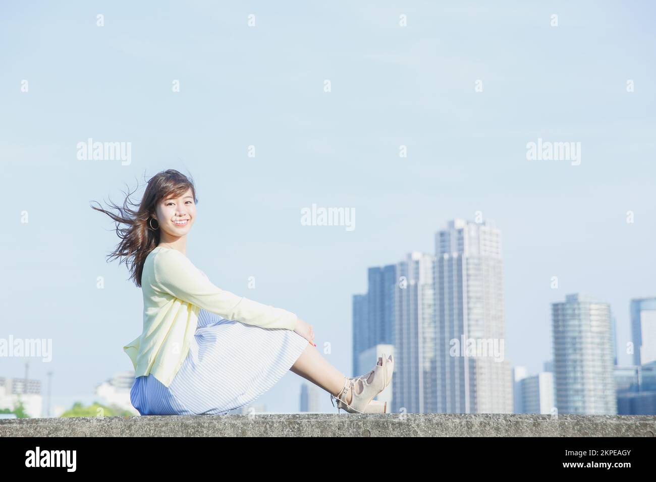 Japanese woman sitting on the sea barrier Stock Photo - Alamy