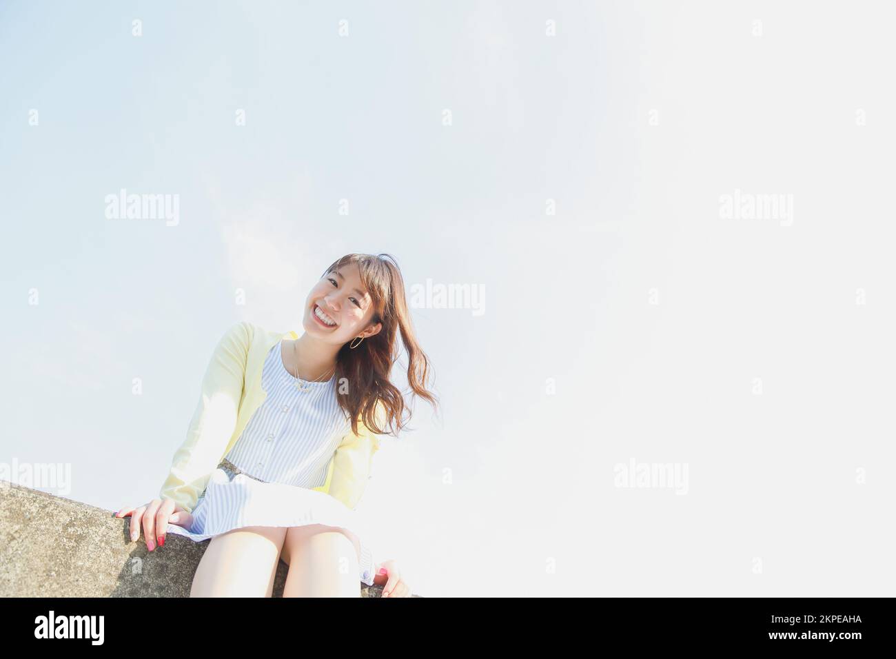 Japanese woman sitting on the sea barrier Stock Photo - Alamy