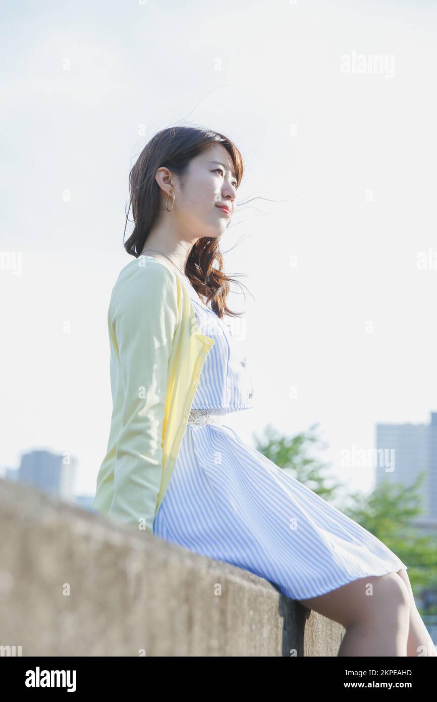 Japanese woman sitting on the sea barrier Stock Photo - Alamy