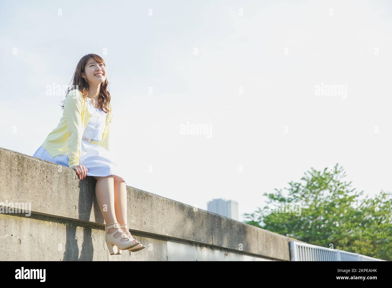 Japanese woman sitting on the sea barrier Stock Photo - Alamy