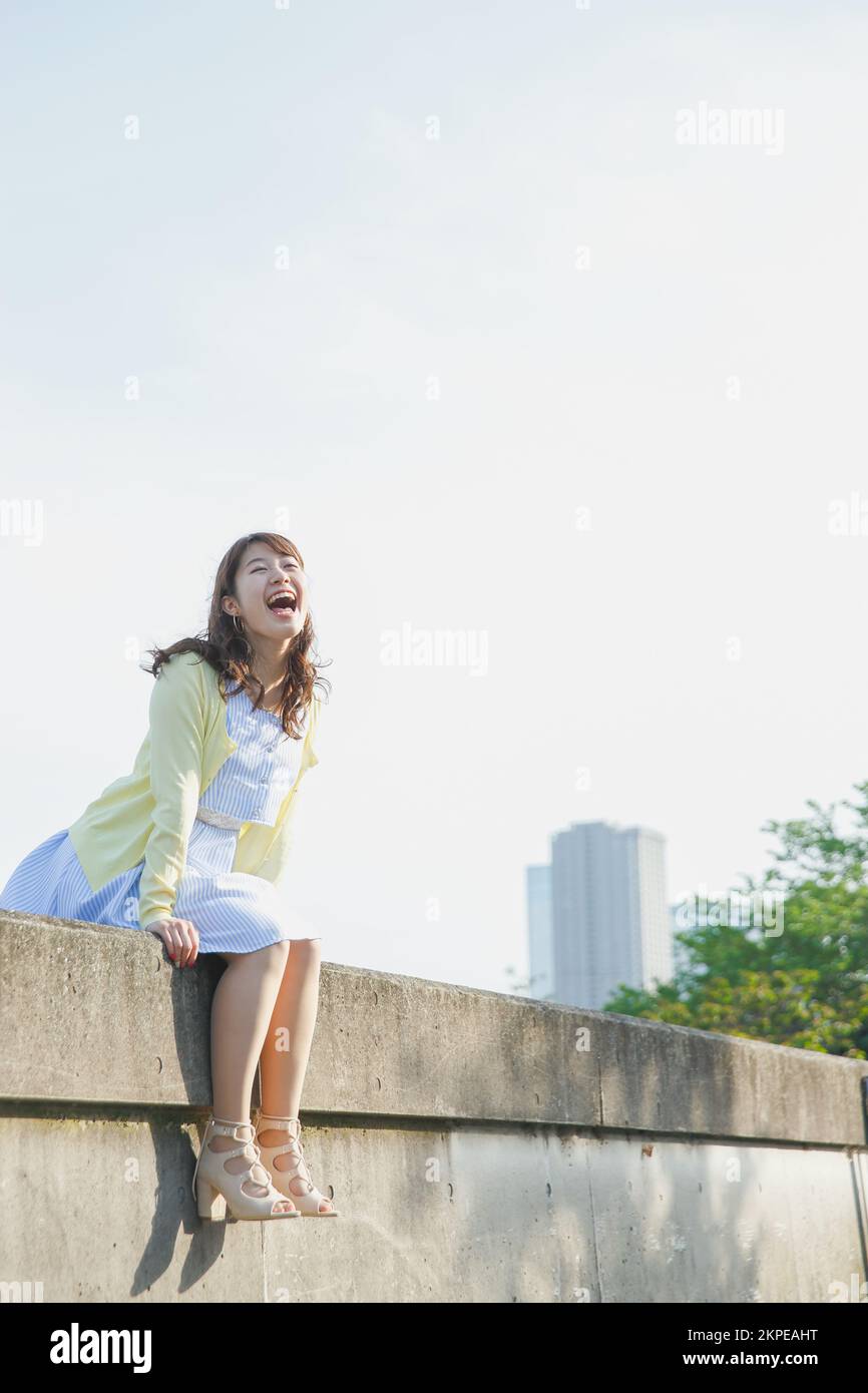Japanese woman sitting on the sea barrier Stock Photo - Alamy