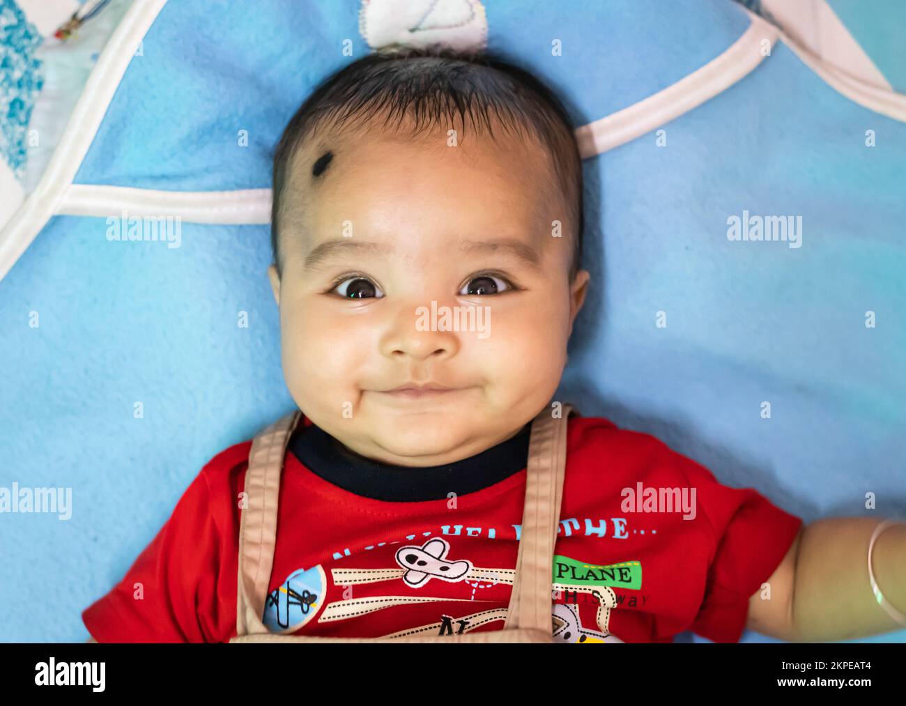 cute infant facial expressing from top angle indoor shot Stock Photo