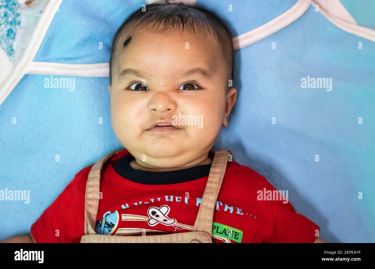 cute infant facial expressing from top angle indoor shot Stock Photo
