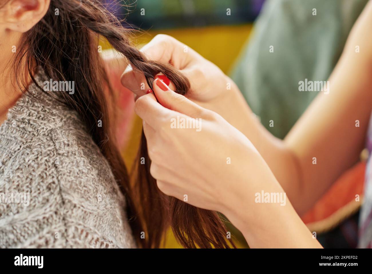 Styling, hair care and hands of friends braiding at a salon, grooming and fun together in a house. Hairstyle, stylist and girl at a hairdresser for Stock Photo