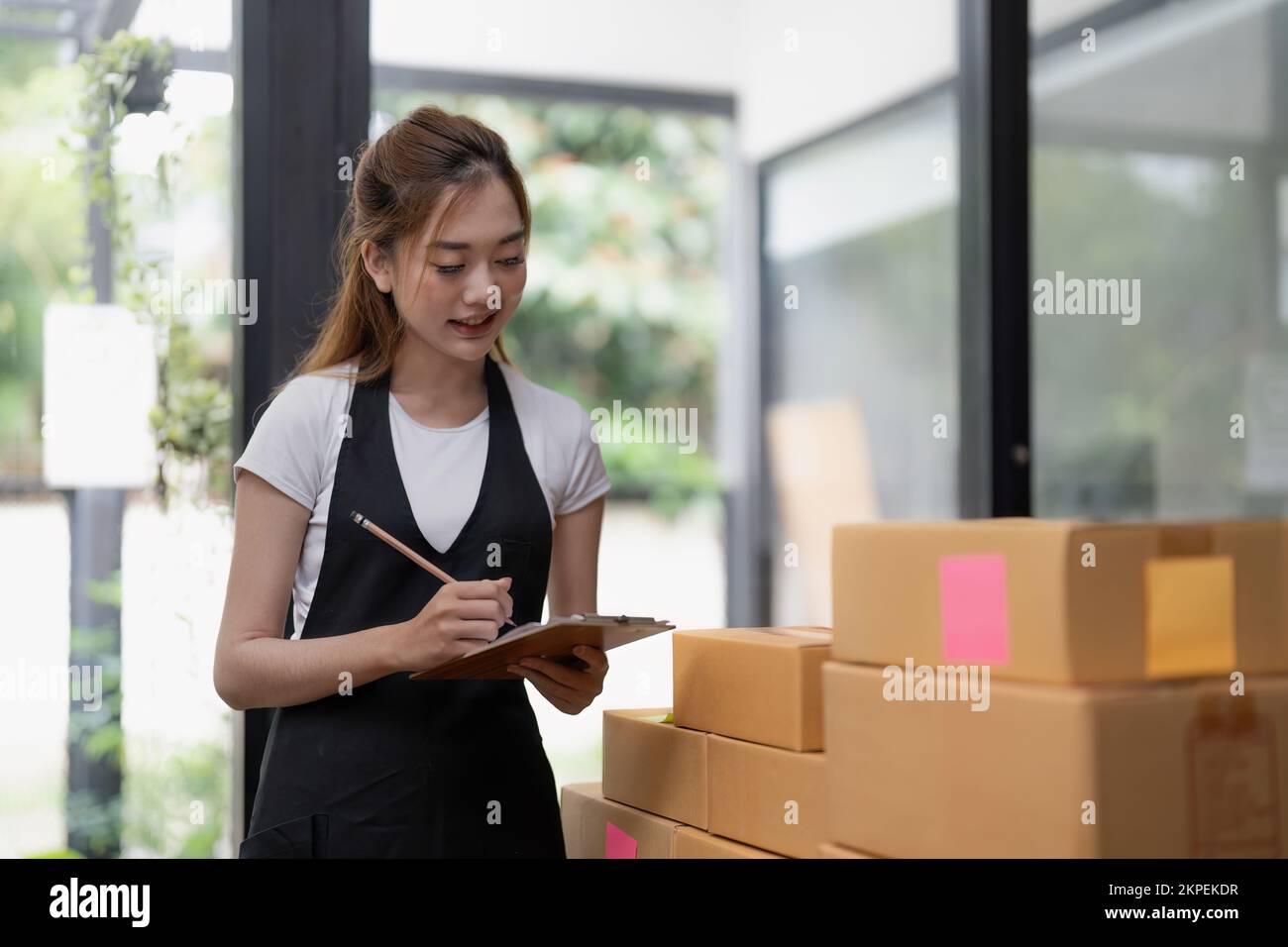 business woman checking customer order online shipping boxes at home. Starting Small business entrepreneur SME freelance. Online business, Work at Stock Photo
