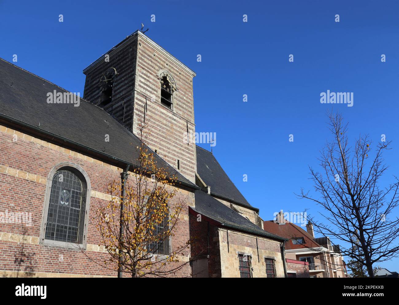 View of the historic Our Lady's parish church in Nieuwerkerken near Aalst in East Flanders, Belgium. Sunny autumn day with clear sky, and copy space a Stock Photo