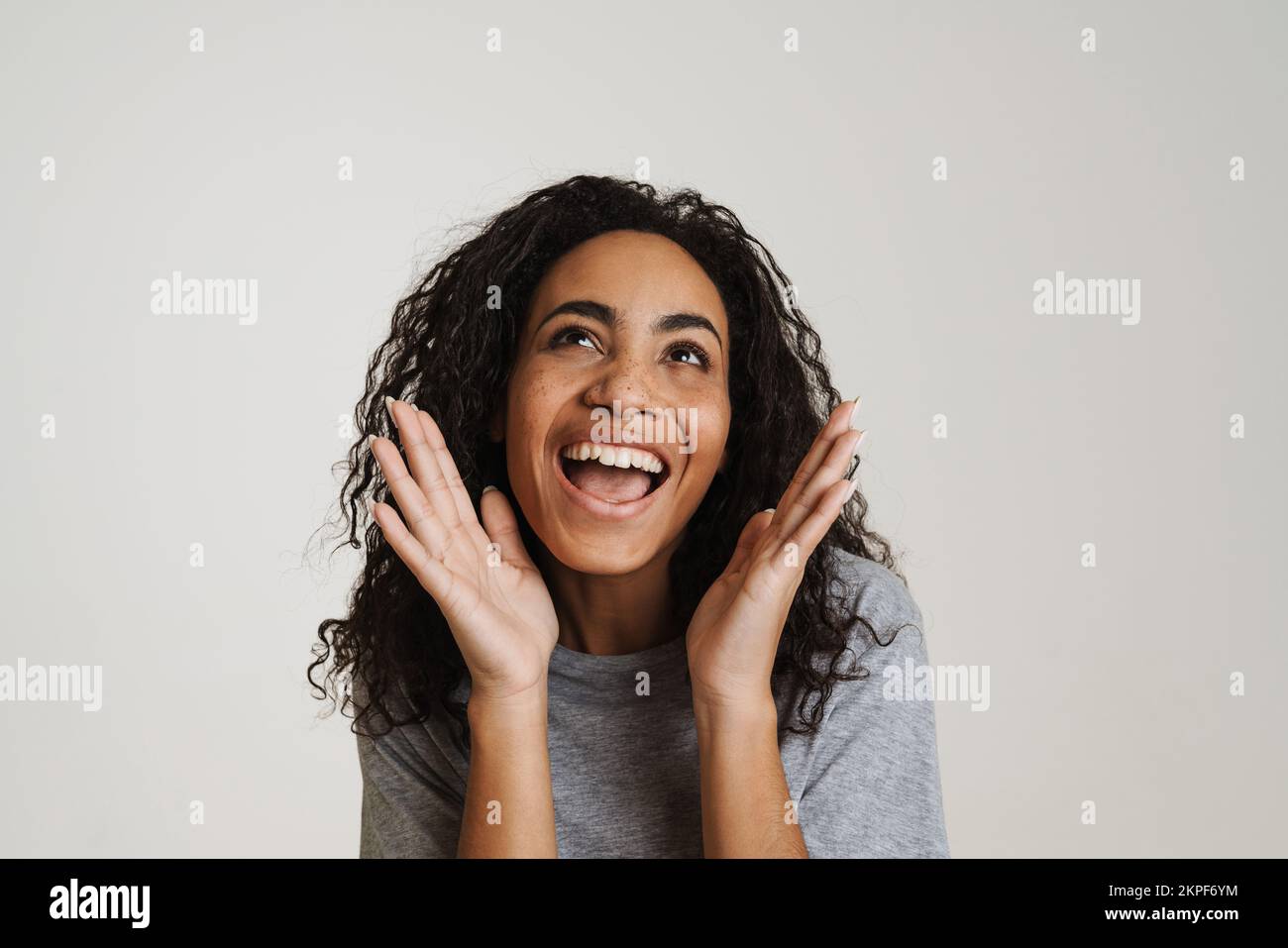 Young black woman with wavy hair laughing and gesturing isolated over ...