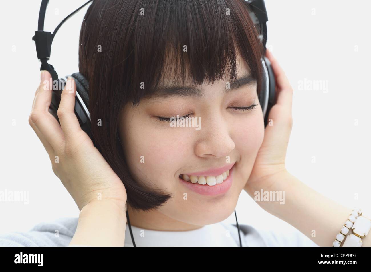 Young Japanese woman listening to music with headphones Stock Photo Alamy