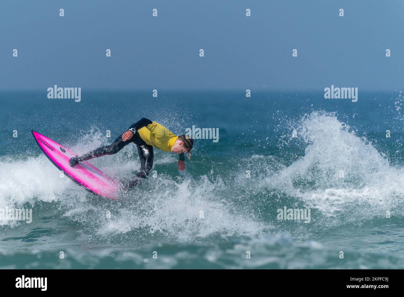 A young male surfer competing in a surfing competition at Fistral in Newquay in Cornwall in the UK. Stock Photo